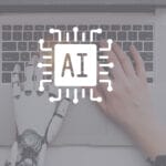 A human hand and a robotic hand type on a laptop keyboard, with an AI microchip icon overlay at the center.