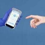 A gloved hand holds a smartphone displaying a health app as an ungloved hand reaches toward it, against a blue background.