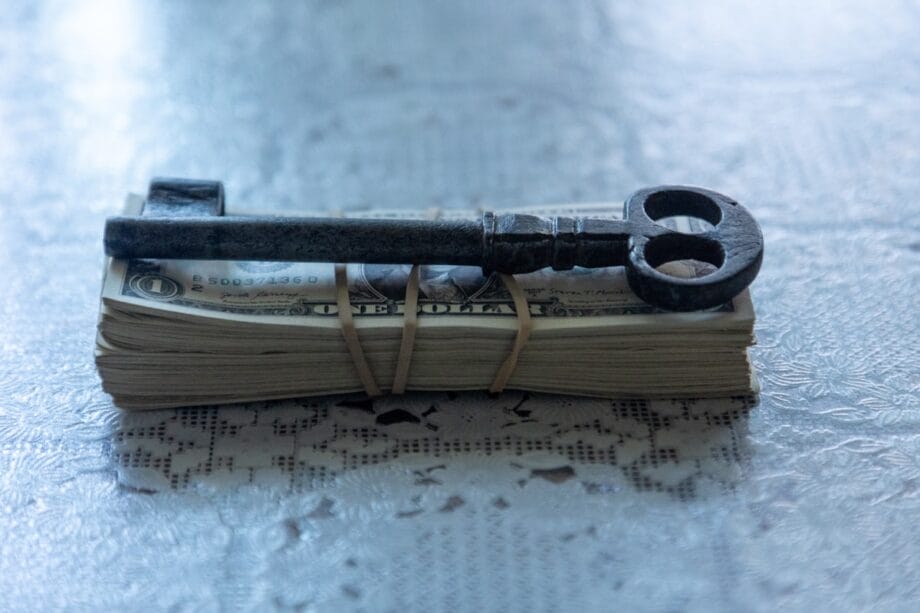 A pair of scissors sitting on top of a pile of money