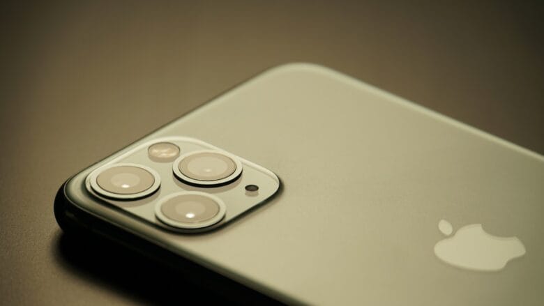 Close-up of the back of an iPhone, focusing on the triple camera lenses and Apple logo.