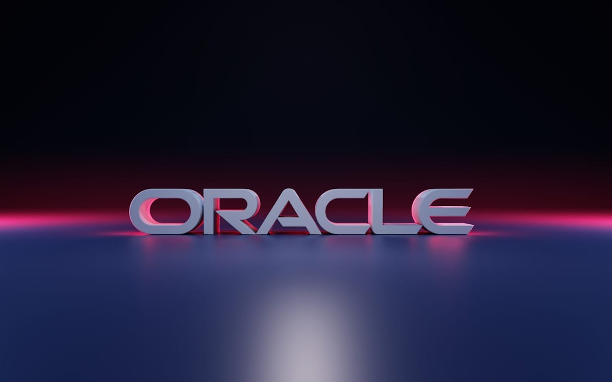 The word ORACLE in bold, 3D letters is displayed on a reflective surface with a dark gradient background.