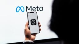 a person holding a cell phone in front of a large screen