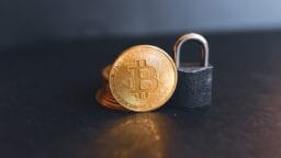 a bit coin sitting on top of a padlock