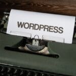a close up of a typewriter with the word wordpress printed on it