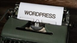 a close up of a typewriter with the word wordpress printed on it