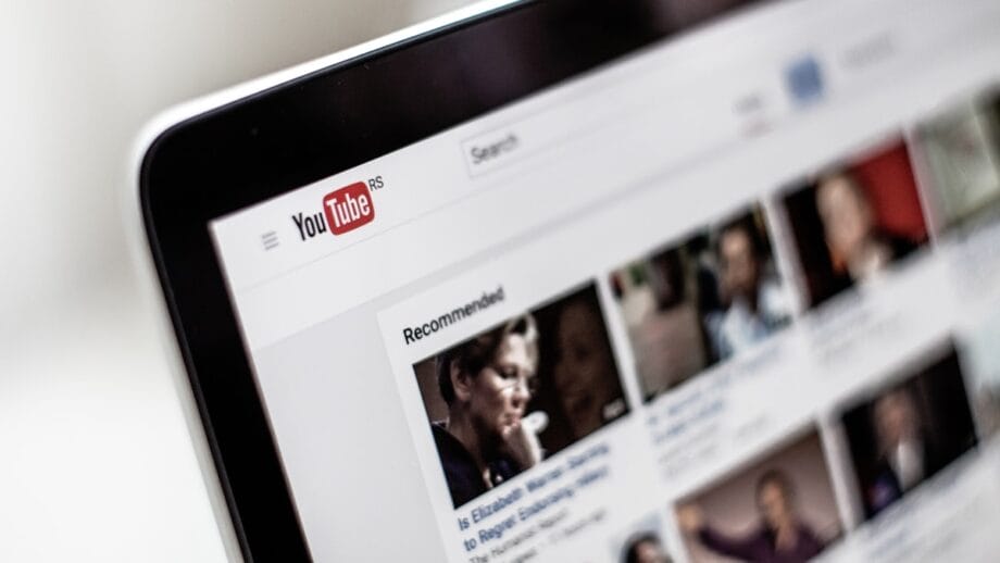 Close-up of a computer screen displaying the YouTube homepage with recommended video thumbnails visible.