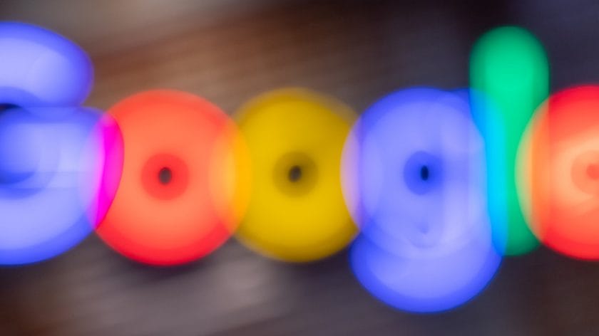 Blurred image of the Google logo with indistinct, colorful letters on a dark background.