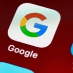 Close-up of the Google app icon and label on a smartphone screen, next to the Twitter app icon.