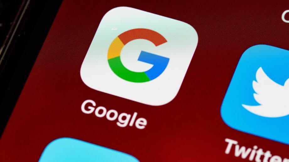 Close-up of the Google app icon and label on a smartphone screen, next to the Twitter app icon.