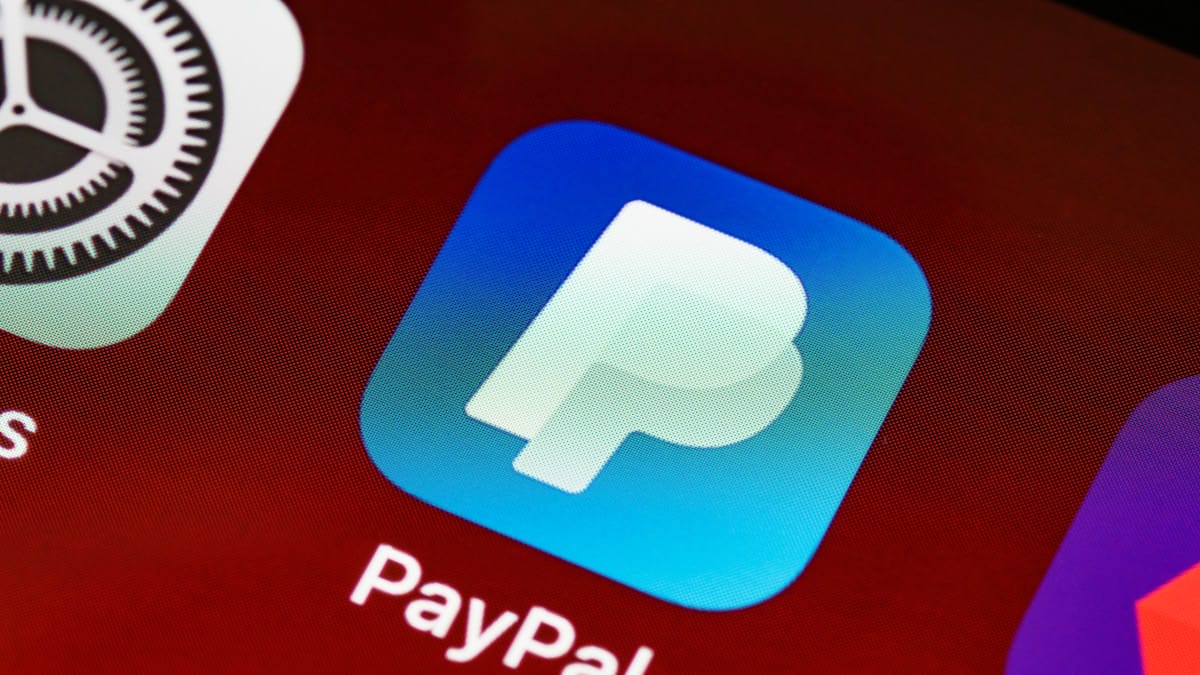 Close-up of the PayPal app icon displayed on a smartphone screen with other app icons visible nearby.