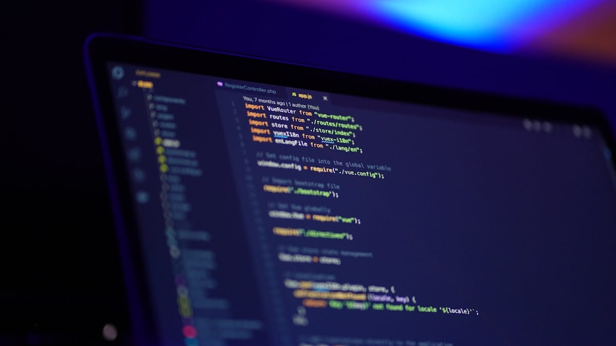 A computer screen displays a code editor with JavaScript code and a list of files on the left sidebar.