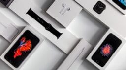 Boxes of various Apple products including iPhones, Apple Watch, Apple Pencil, Apple Watch band, and AirPods arranged on a white surface.