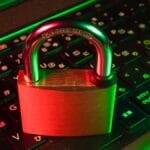 A padlock placed on a laptop keyboard, symbolizing cybersecurity or data protection.