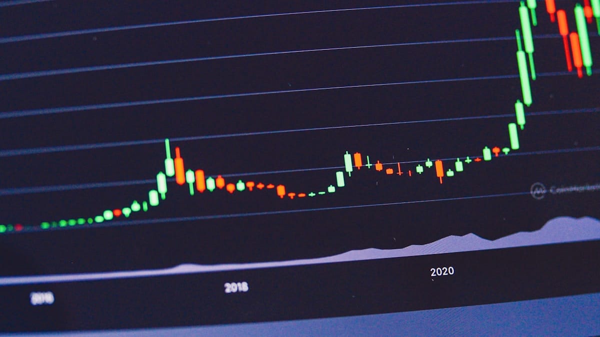 A digital candlestick chart showing cryptocurrency price fluctuations from 2016 to 2021, with a sharp increase after 2020.