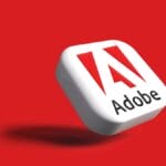 A 3D square with the Adobe logo and text on a red background, casting a shadow to the left.