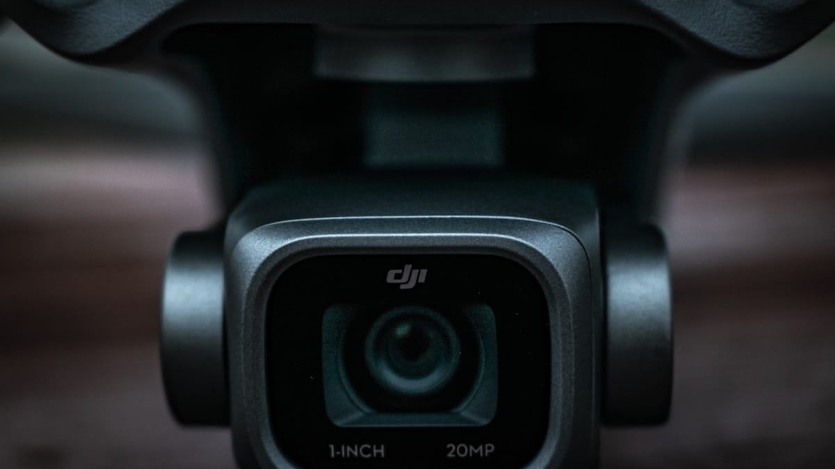 Close-up of a DJI camera lens displaying 1-INCH 20MP text on the bottom edge of the camera housing.