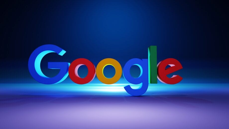 The Google logo in 3D colorful letters stands on a reflective surface with a blue gradient background.