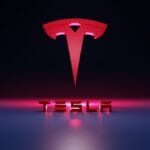 Red Tesla logo above the word TESLA in bold 3D letters, set against a dark background with pink and blue lighting effects.