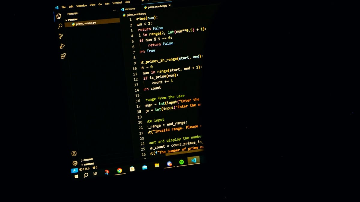 A computer screen displays Python code in a dark-themed text editor, showing a function to find prime numbers in a range.
