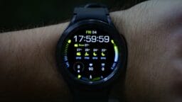 A smartwatch on a wrist displays the time, date, weather forecast, fitness stats, and step count.