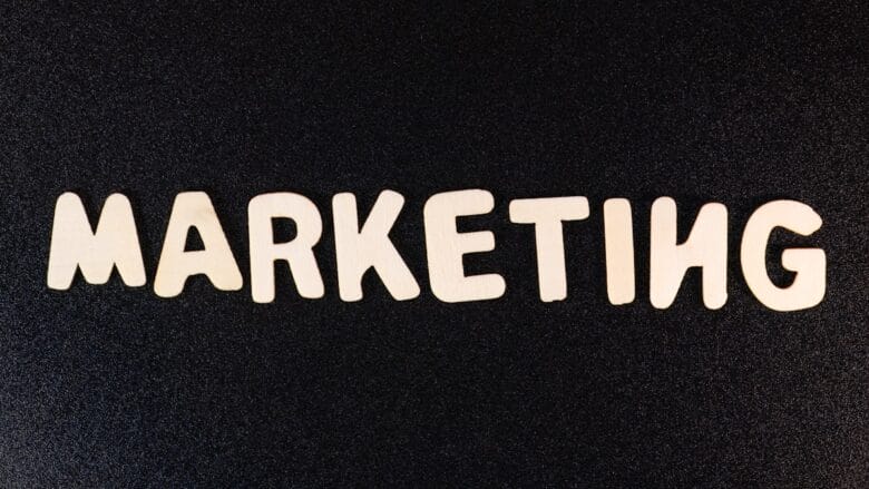 The word MARKETING spelled out in large, light-colored letters on a textured black background.