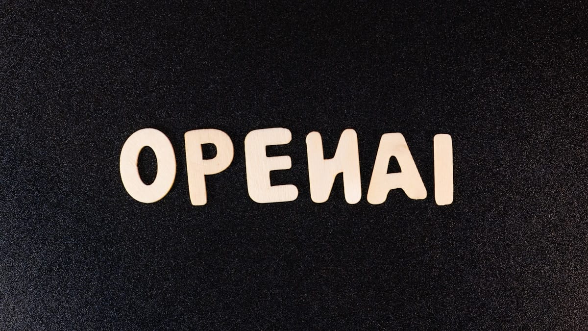 Wooden letters spelling OPENAI are arranged on a textured black surface.