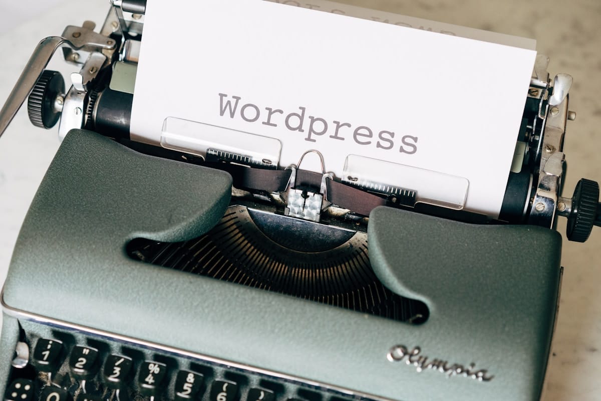 A typewriter with a sheet of paper displaying the word Wordpress typed in large, clear letters.
