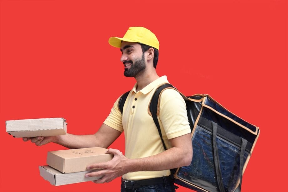 a man in a yellow hat holding a box