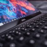 A close-up of a Dell laptop keyboard with a colorful abstract wallpaper displayed on the screen.