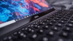 A close-up of a Dell laptop keyboard with a colorful abstract wallpaper displayed on the screen.