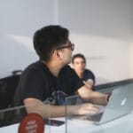 man in black crew neck t-shirt using macbook pro