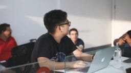 man in black crew neck t-shirt using macbook pro
