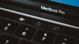 Close-up of a MacBook Pro keyboard, focusing on the Touch Bar with an eye icon and share button visible.