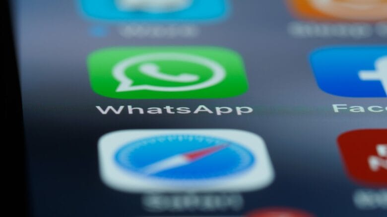 Close-up of a smartphone screen displaying the WhatsApp app icon among other app icons.