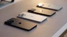 Three iphones sitting on a table next to each other