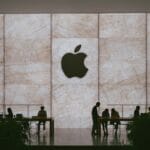 a group of people standing in front of an apple logo