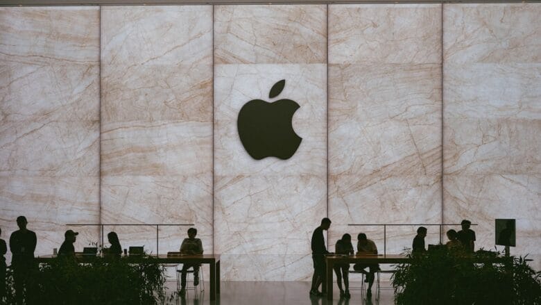 a group of people standing in front of an apple logo