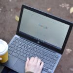a person using a laptop computer with a cup of coffee