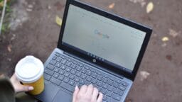 a person using a laptop computer with a cup of coffee
