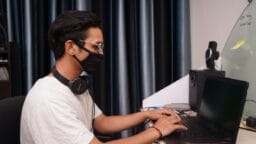man in white crew neck t-shirt using black laptop computer