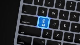 A computer keyboard with a glowing blue AI key, featuring a robot face icon, replacing the A key.
