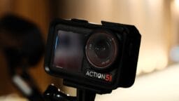 A black action camera sitting on top of a tripod