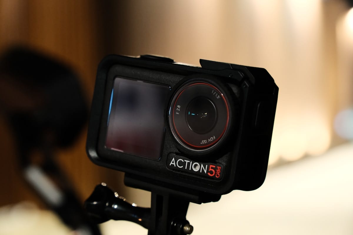 A black action camera sitting on top of a tripod