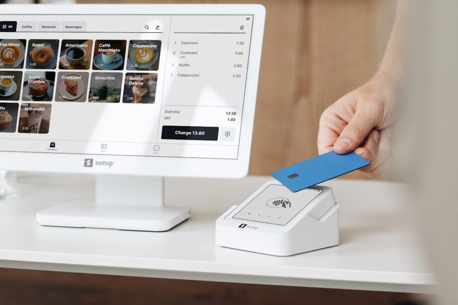 A person holding a blue card in front of a computer