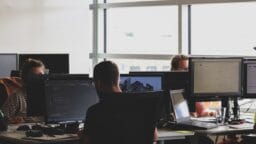 people sitting on chair in front of computer monitor