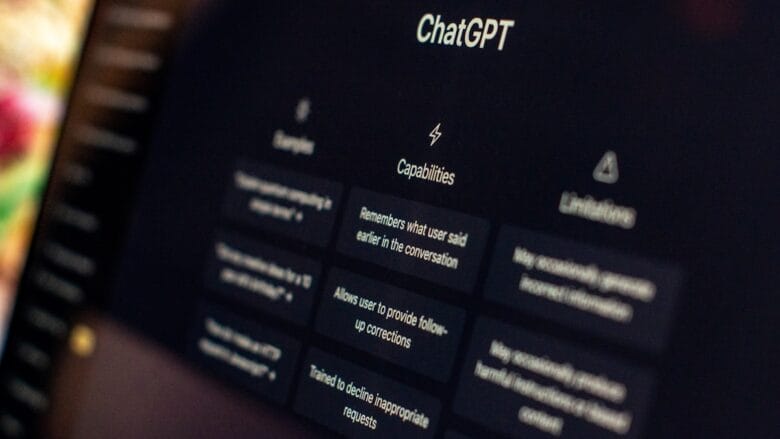 A computer screen displays the ChatGPT interface with sections for examples, capabilities, and limitations visible.