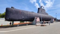 a large black submarine sitting on top of a road