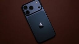 Dark blue smartphone with apple logo on brown surface