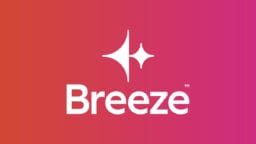 White geometric HubSpot Breeze AI logo on a pink and orange gradient background.