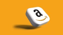 A 3D square icon with the Amazon logo on a solid orange background, casting a shadow below.